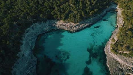 clear turquoise blue sea water in a remote natural bay with white sand beach, palma de mallorca island