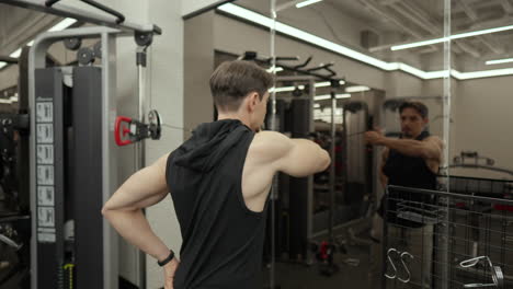 sporty man training shoulders in gym