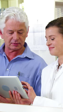 pharmacists using digital tablet at counter