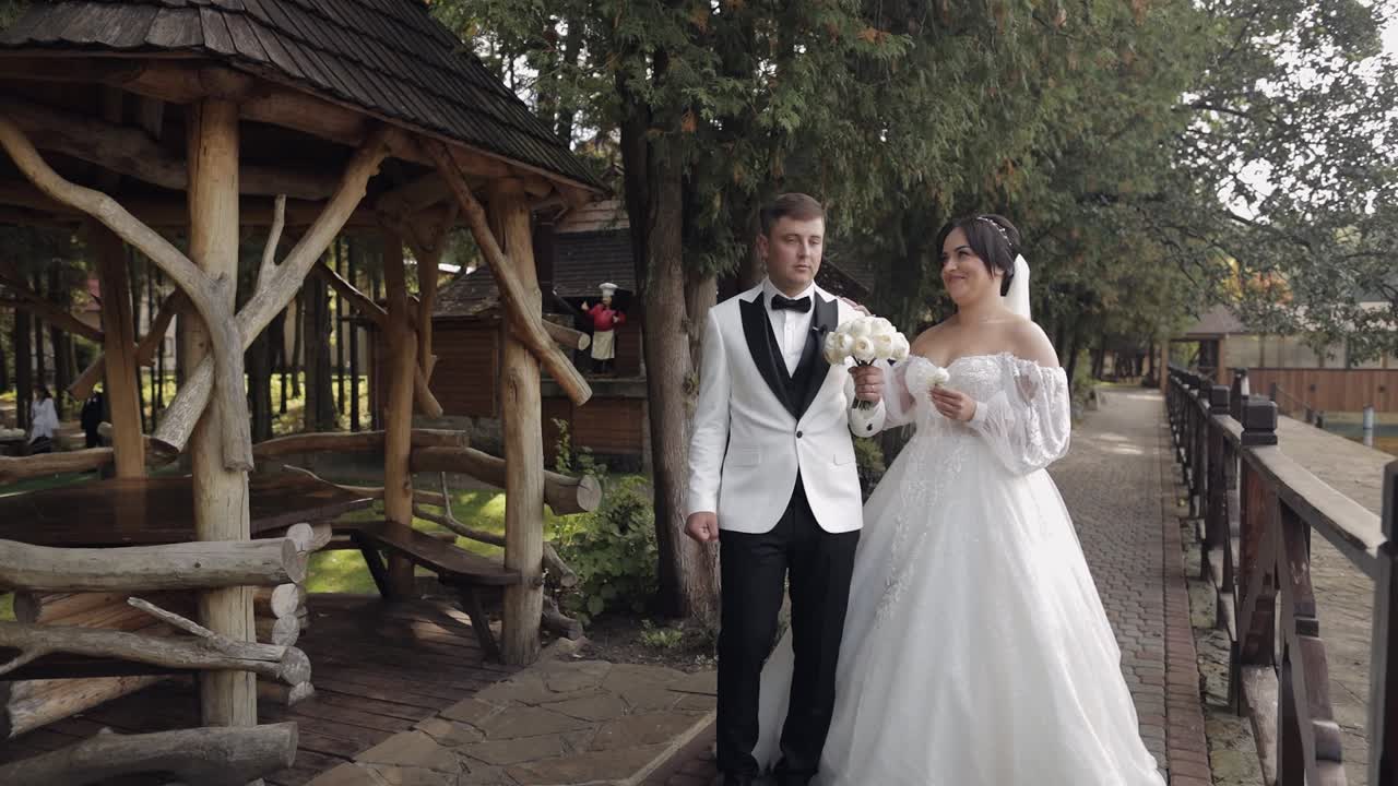 Encantadores recién casados, novia y novio caucásicos con ramo en el parque, primer encuentro de la pareja.