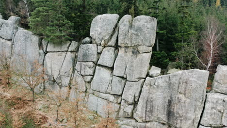 natural stone wall massif,coniferous forest behind it,autumn,czechia