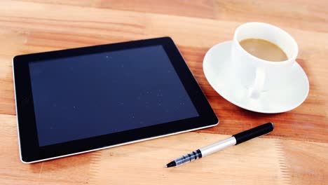 digital tablet with pen and cup of coffee