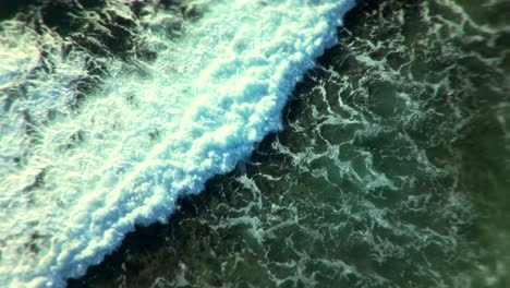 las olas del océano chocando contra la orilla rocosa