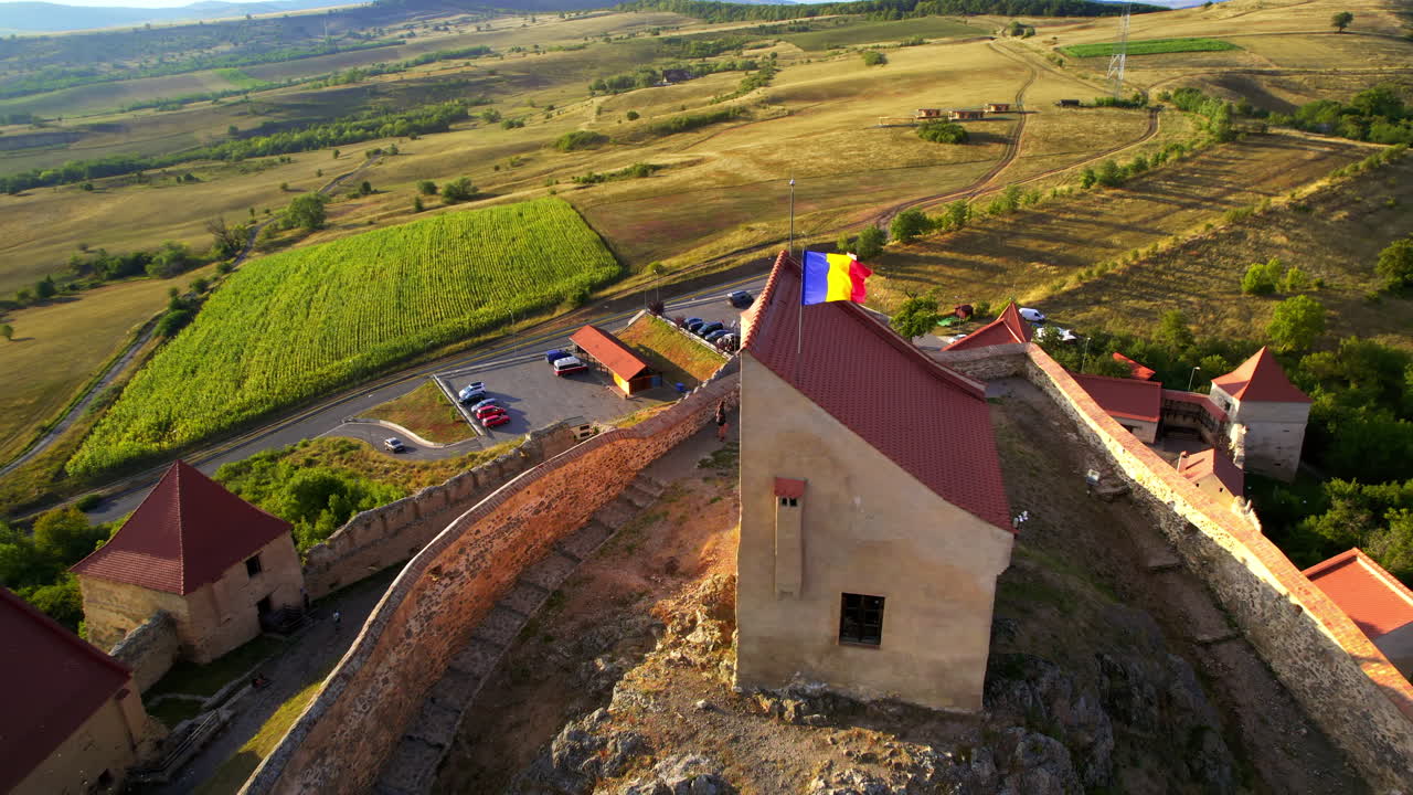 Vista aerea con drone della rocca di Rupea al tramonto, Romania. Cittadella situata su una scogliera, turisti, vegetazione