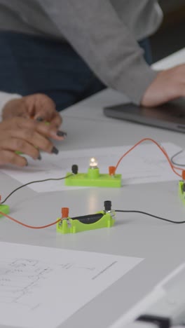 vertical shot of students hands as they work on engineering project