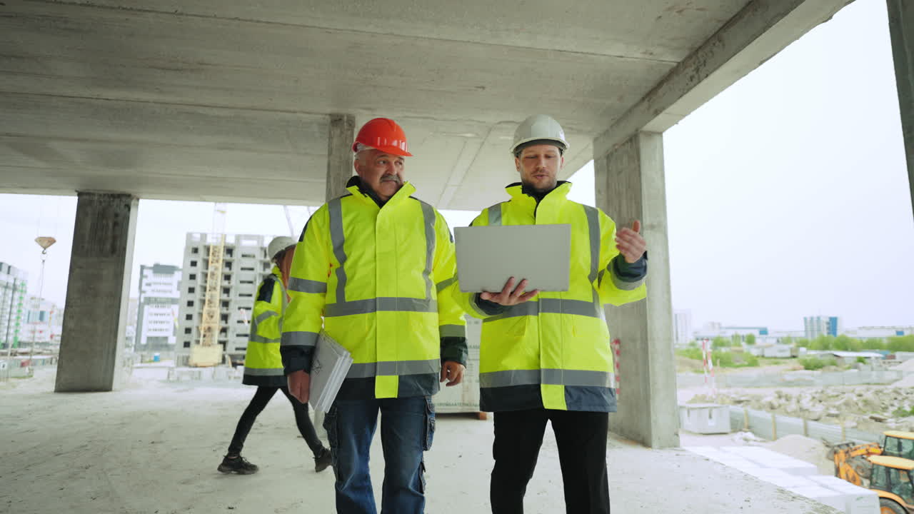 dos ingenieros civiles están viendo un edificio en construcción. los constructores profesionales están controlando la construcción.