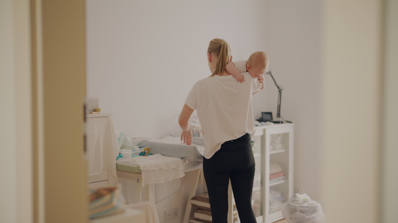 Woman changing baby's diaper