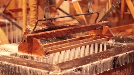 old-fashioned machine dipping candles in wax