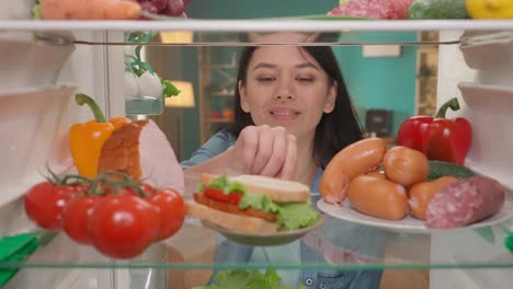 woman checking refrigerator for food