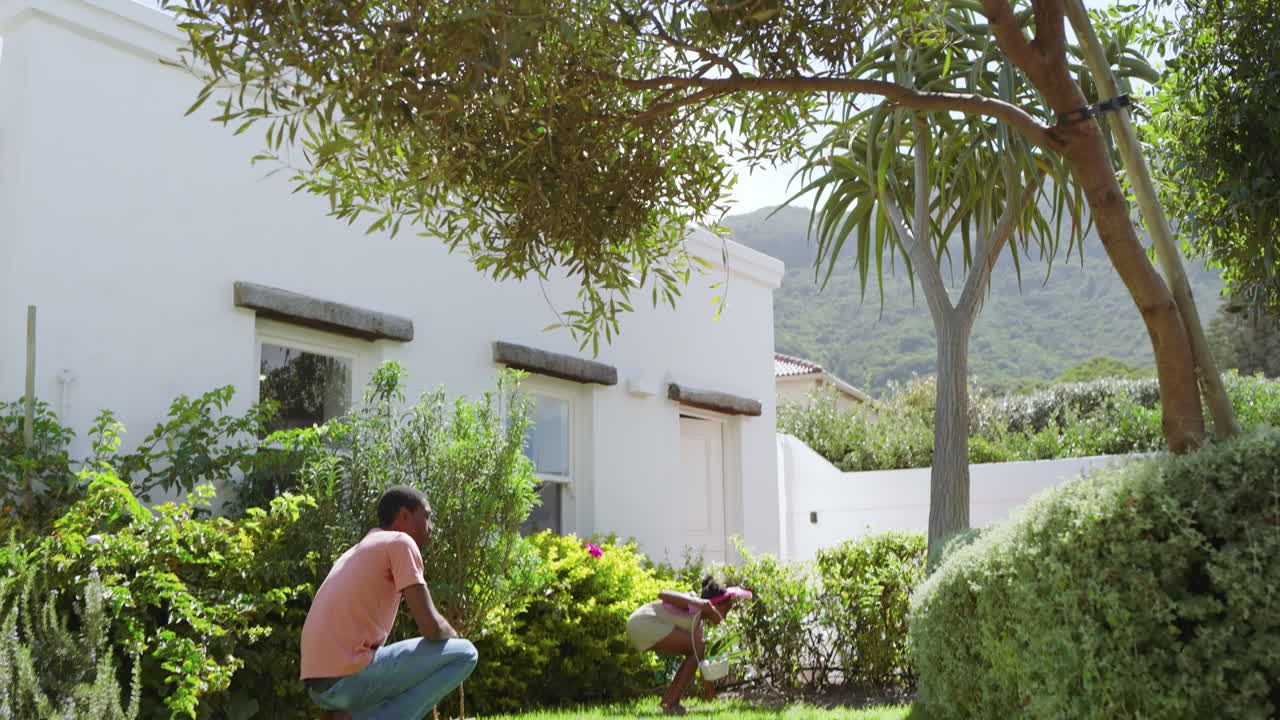 Easter, african american father hugging daughter in sunny garden, enjoying diverse family time