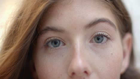 close-up of young woman with blue eyes and light brown hair, looking thoughtful