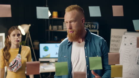 un tipo hipster molesto explicando un proyecto a una colega en la oficina nocturna