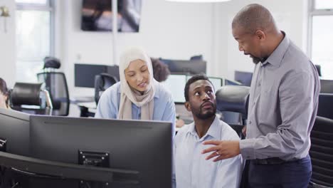 Group-of-happy-diverse-business-people-using-computer-and-talking-in-office,-slow-motion