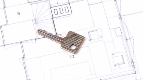 close up of a house plan and a key turning