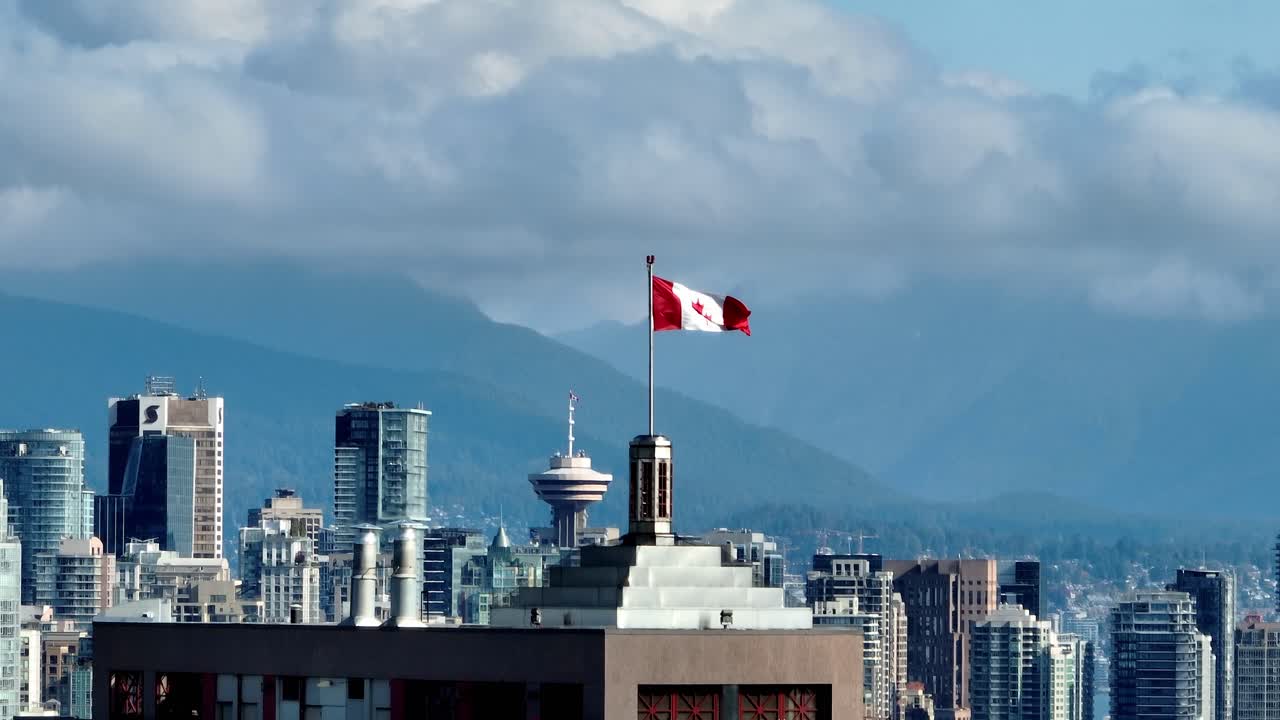 Bandiera canadese in cima a un grattacielo nello skyline del centro di Vancouver