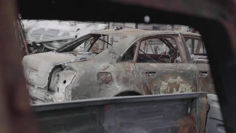 View-of-Heavily-Fire-Damaged-Sedan-through-Another-Car-Window---Vehicle-Destroyed-in-Wildfire---4K