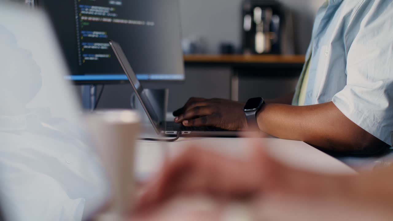 Person coding on a laptop in an office