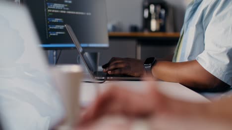 person coding on a laptop in an office