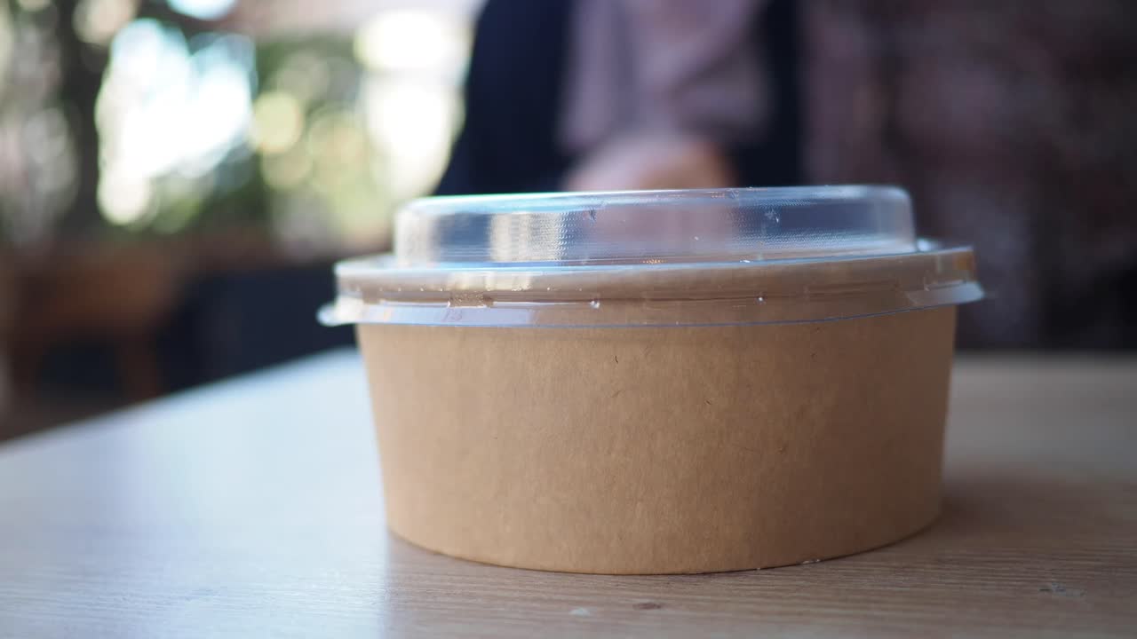 Hands holding a food container