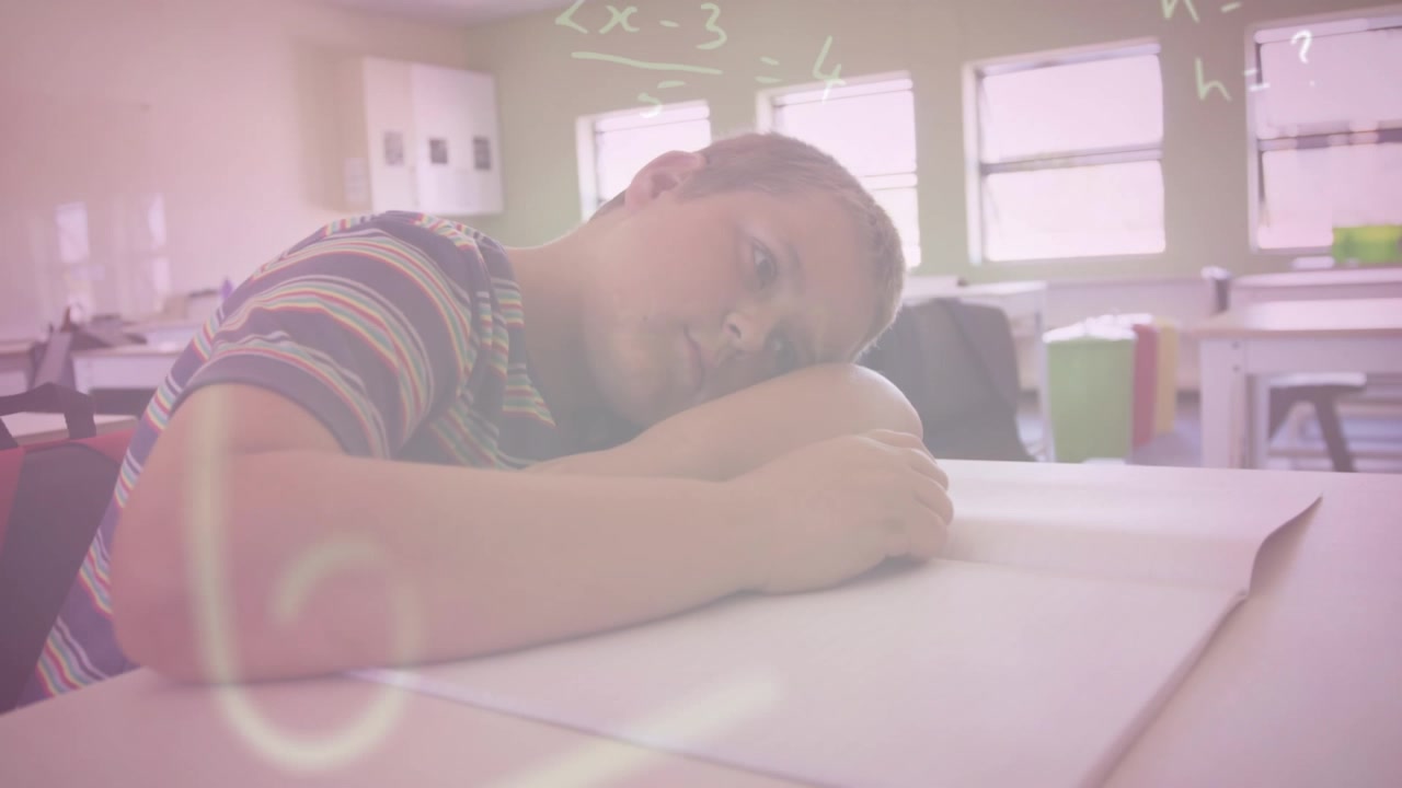 Animazione di formule matematiche su un ragazzo caucasico stanco sdraiato sulla scrivania a scuola