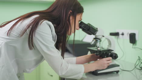 scientist examining sample under microscope in laboratory