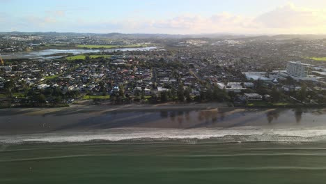 Tripod-drone-video-of-waves-rolling-in-along-the-shoreline-during-golden-hour