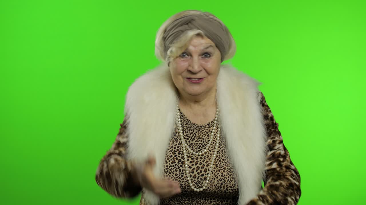 пожилая стильная бабушка. кавказская женщина аплодирует руками. ключ хромы