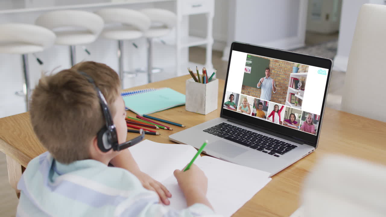 Menino estudante usando laptop para aula online em casa, com um(a) professor(a) de diversas origens e a turma na tela.
