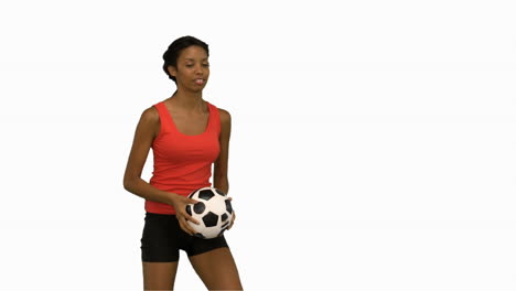 mujer haciendo malabarismos con un fútbol en la pantalla blanca