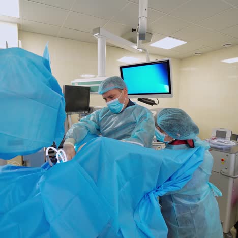 surgery in the operating theater. group of doctors in blue uniform conduct a surgery on the background of modern medical equipment. health care concept.