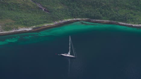 Luftaufnahme-Eines-Bootes,-Das-Im-Blauen-Meer-Mit-Ruhigem-Wasser-In-Norwegen-Verankert-Ist