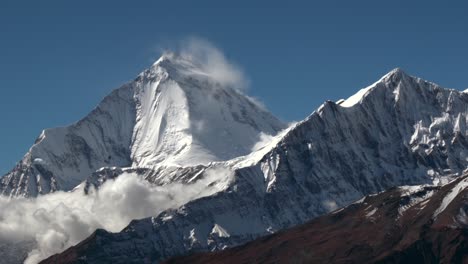 a time-lapse of clouds moving over a snow covered mountain in the himalayas of nepal