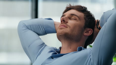 closeup man relaxing dreaming at office. calm director stretching body workplace