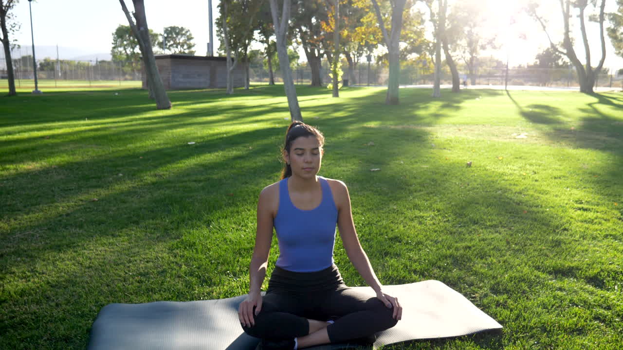 una hermosa joven hispana en meditación y respiración profunda por su salud mental en la naturaleza al amanecer