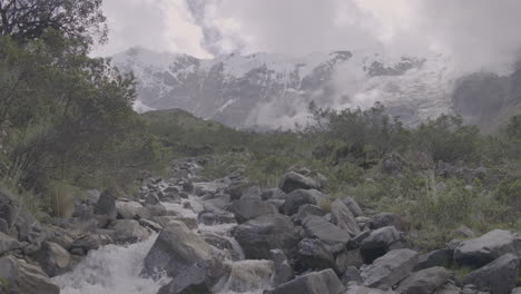 tilting up shot of a powerful river flowing down the mountain in slowmotion near the humantay lake peru log