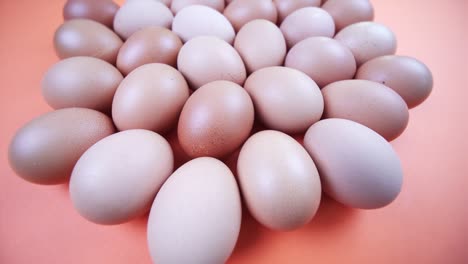 numerous chicken eggs on orange background extreme close