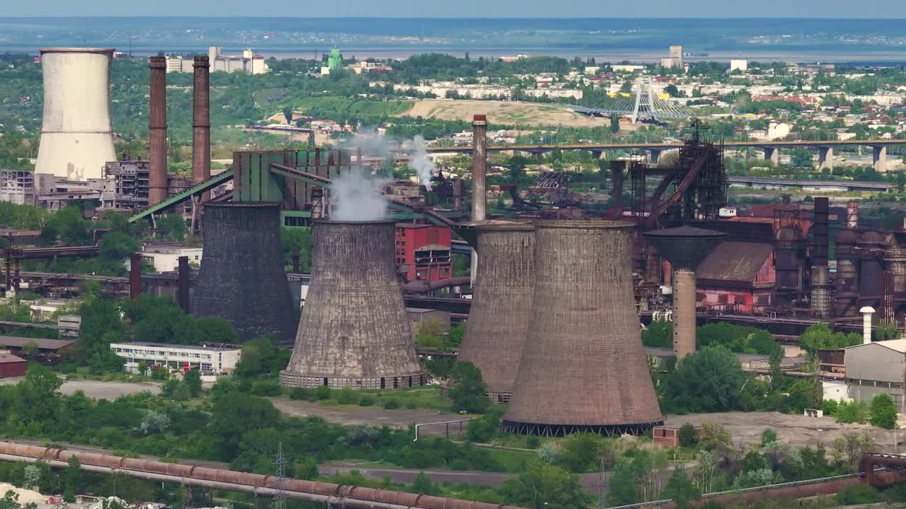 chimeneas industriales establecidas contra el horizonte de una ciudad distante en un día soleado y despejado, disparo de cerca
