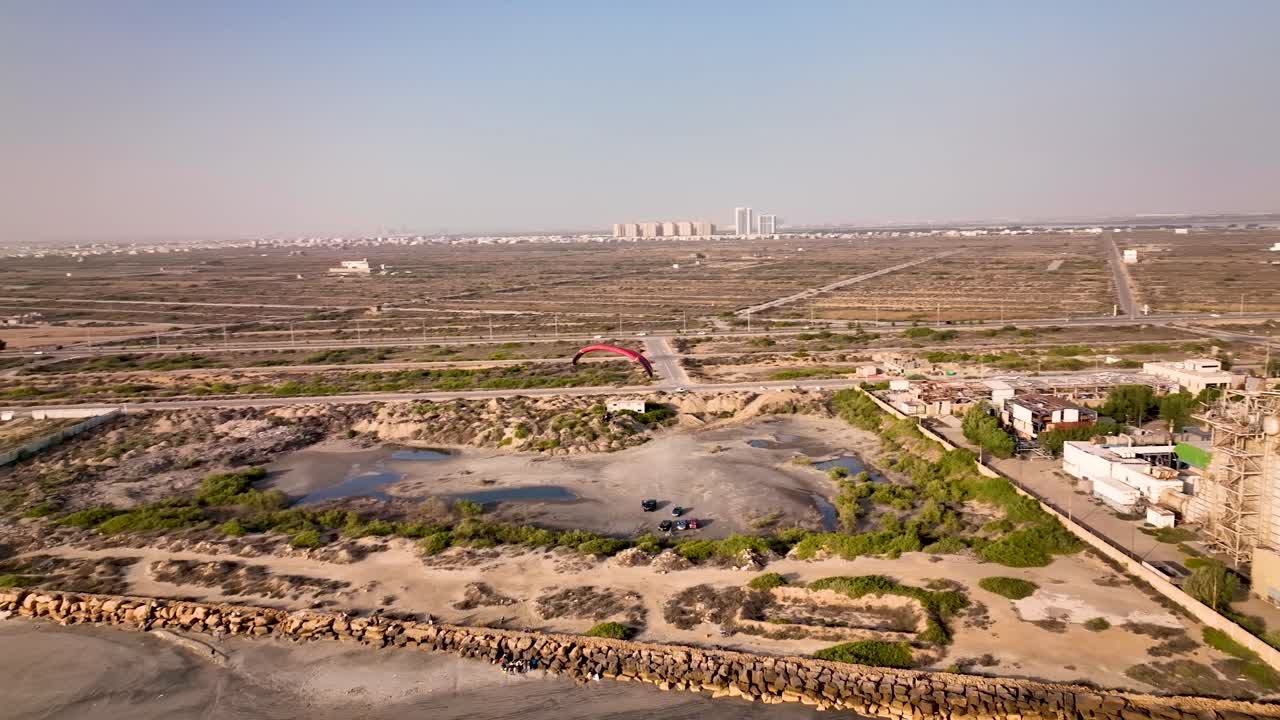 vista aérea del parapente sobrevolando la playa de karachi durante la puesta de sol