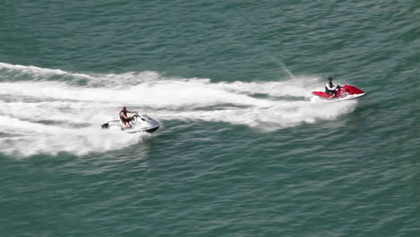 two jet skis race across the water