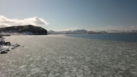 cinematic aerial shot of sea ice near the selfoss area in iceland with mountains in the background