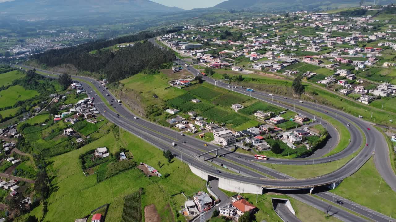 Witness the majestic Santa Rosa Curve from an elevated perspective with this zoom-out aerial video in Cutuglahua parish, Mej&iacute;a Canton
