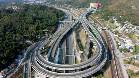 Verkehr-Auf-Einem-Massiven-Autobahnkreuz-Mit-Mehreren-Ebenen-Und-Schleifenförmiger-Straße-In-Hongkong,-Luftbild