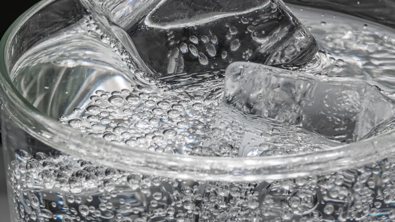 어두운 파란색 배경 에 얼음 이 있는 물 한 잔