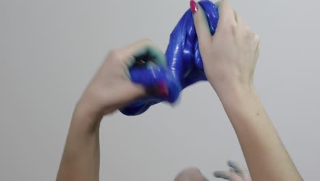 Woman-and-child-hands-playing-satisfying-blue-slime-gooey-substance.-Antistress