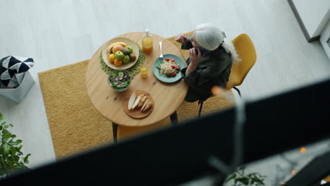 senior woman dining and talking on the phone