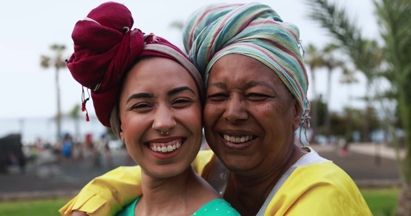 Happy African Women Wearing Traditional Head Wraps Smiling at Camera