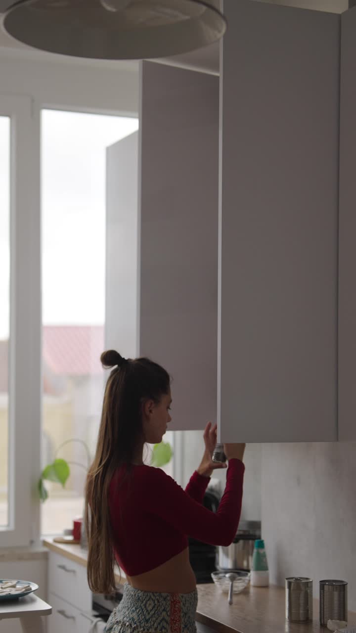 mujer abriendo el armario de la cocina