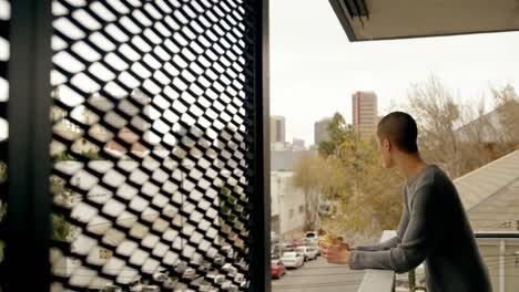 man having coffee while standing in balcony 4k