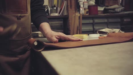 unrecognizable tanner cleaning back of leather chair made in an artisanal way