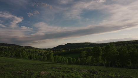 cloudscape over meadow forest and mountain ridge. timelapse